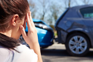 car accident lawyer Manhattan, NY with a woman holding her head in front of rear-end car accident